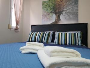 a blue bed with towels on top of it at Nanaapartments in Perea