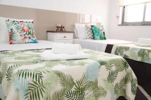サン・バルトロメウ・デ・メシネスにあるCasa do adro 3のベッドルーム1室(緑の葉のあるベッド2台付)