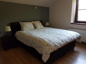 1 dormitorio con 1 cama con edredón blanco y 2 lámparas en La parenthèse, en Chimay