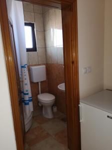 a small bathroom with a toilet and a window at Rooms Ibrocevic in Ulcinj