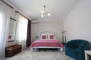 a bedroom with a bed and a blue chair at Union Square Apartment 2 in Cluj-Napoca