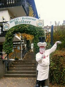 a statue of a chef standing in front of a hotel at Hotel Waldsee in Waldachtal