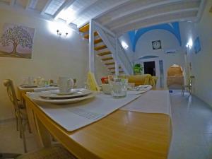 a dining room with a table and a staircase at A casa tu zi Melu in Felline