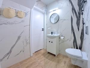 a bathroom with a toilet and a sink and a mirror at Baltic Pearl in Ustka +52 photos