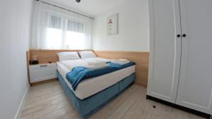 a small bedroom with a bed and a window at Baltic Pearl in Ustka
