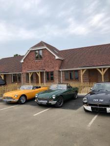 three cars parked in a parking lot in front of a house at Hamilton Arms Suites in Midhurst