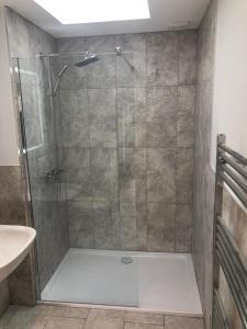 a shower with a glass door in a bathroom at Hamilton Arms Suites in Midhurst