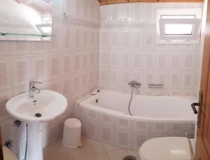 een badkamer met een wastafel, een bad en een toilet bij EFTIHIA in Kavos