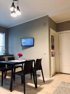 a dining room with a table and chairs and a tv on the wall at Medus in Ventspils