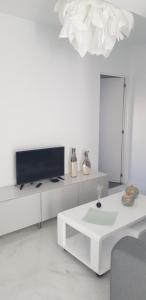 un soggiorno bianco con TV e tavolo bianco di Bubu Beach 2-A a Los Cristianos