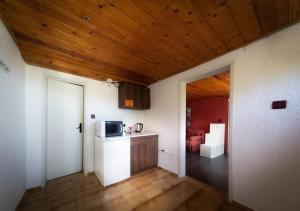 a kitchen with a white refrigerator and a wooden ceiling at Alexander Bungalows in Shkorpilovtsi