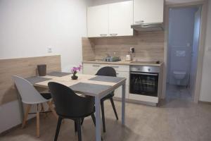 a kitchen with a table and chairs in a kitchen at Bungalov comfort - 100 m from the beach in Premantura