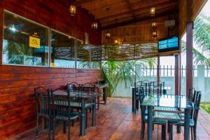 a restaurant with tables and chairs on a patio at Elegant Green Beach Resort in Trincomalee