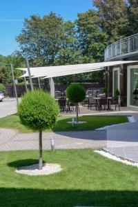 a tree in the grass in front of a building at Holiday Resorts in Balatonszárszó