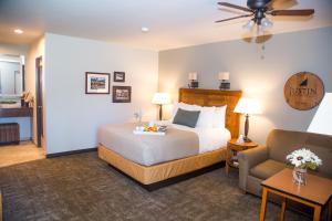 a hotel room with a bed and a couch and a chair at Adelaide Inn in Paso Robles