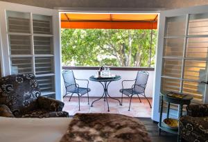 un porche cubierto con mesa y sillas en Mirabelle Inn & Restaurant, en Solvang