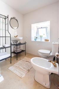 ein Badezimmer mit einem weißen WC und einem Waschbecken in der Unterkunft Lagar do Sapateiro in Fontes