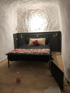 Cama en habitación con pared de ladrillo en The Blacklighters Opal Retreat-Undergound, en Coober Pedy