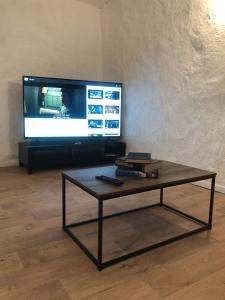 a living room with a coffee table and a television at The Blacklighters Opal Retreat-Undergound in Coober Pedy