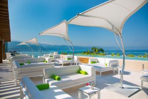 - un ensemble de canapés et de chaises blancs sur la terrasse dans l'établissement Krystal Grand Puerto Vallarta - All Inclusive, à Puerto Vallarta