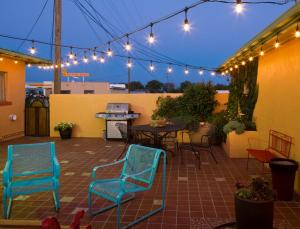 a patio with chairs and a table and lights at Sunset Motel Moriarty in Moriarty