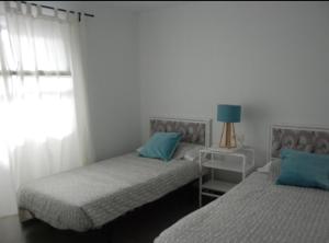 zwei Einzelbetten in einem Zimmer mit Fenster in der Unterkunft Bonito y espacioso apartamento al lado de la playa. in Tías