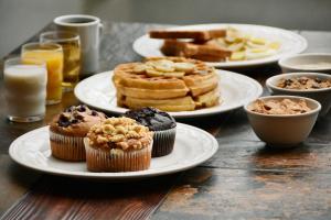 a table with plates of muffins and other pastries at Travelodge by Wyndham Parksville in Parksville