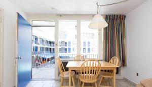 a dining room with a table and chairs and a balcony at Brittany Motel in Wildwood