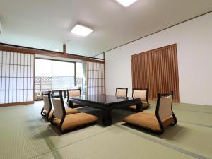 a conference room with a table and chairs and windows at Kikuchi Grand Hotel in Kikuchi