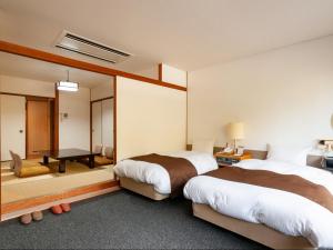 a hotel room with two beds and a mirror at Kikuchi Grand Hotel in Kikuchi +31 photos