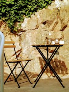 stół z dwoma krzesłami obok kamiennej ściany w obiekcie Villa Regio Garden w mieście Vila do Conde
