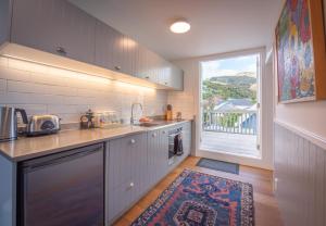 a kitchen with a sink and a large window at Akaroa Waterfront Apartment in Akaroa