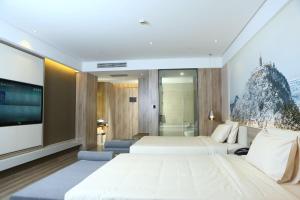 a hotel room with two beds and a flat screen tv at Atour Hotel (Nantong Zhongcheng) in Nantong