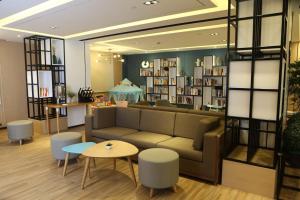 a library with a couch and tables and shelves of books at Atour Hotel (Nantong Zhongcheng) in Nantong