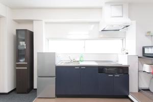 a kitchen with a black and white refrigerator and a sink at East End Building Central Osaka Apartments - Self Check-In Only in Osaka