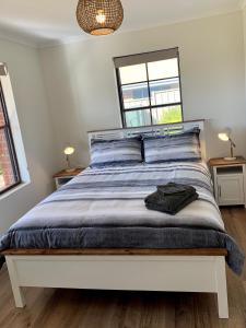 a bedroom with a large bed with two windows at Berds Nest in Emu Bay