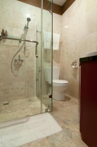 een badkamer met een glazen douche en een toilet bij Villa Mulyono in Batu