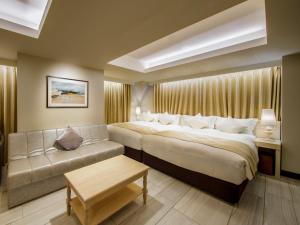 a hotel room with a large bed and a couch at The Centurion Classic Akasaka in Tokyo