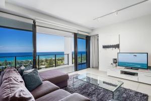 a living room with a couch and a large window at Ultra Broadbeach in Gold Coast