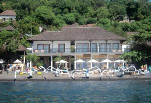a large building on the shore of a body of water at Galang Kangin Bungalows in Amed