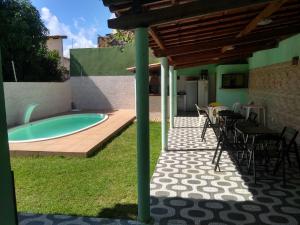 a patio with a hot tub and a table and chairs at Casa Arembepe com Piscina in Camaçari