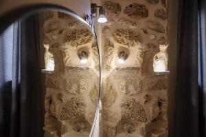 a mirror in a bathroom with a stone wall at To Petrino (VIlla Markos) in Parga