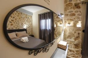 a mirror in a bedroom with a bed with a teddy bear on it at To Petrino (VIlla Markos) in Parga