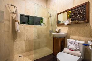 a bathroom with a shower and a toilet and a sink at Villa Mulyono 2 in Batu +7 photos