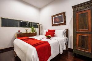 een slaapkamer met een groot bed en een rode deken bij Villa Mulyono 2 in Batu