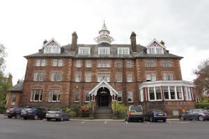 a large brick building with cars parked in front of it at Best Western Station Hotel in Dumfries