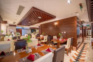 un restaurante con comedor con mesas y sillas en Samdi Da Nang Airport Hotel, en Da Nang