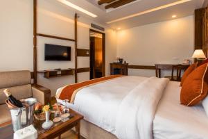 Camera con letto, divano e TV. di Landmark Pokhara a Pokhara