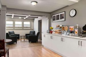 uma sala de espera com cadeiras e um relógio na parede em Travelodge by Wyndham Blairmore em Blairmore