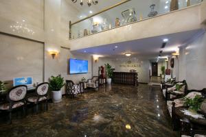 a lobby with chairs and tables in a building at Hotel De La Seine in Hanoi